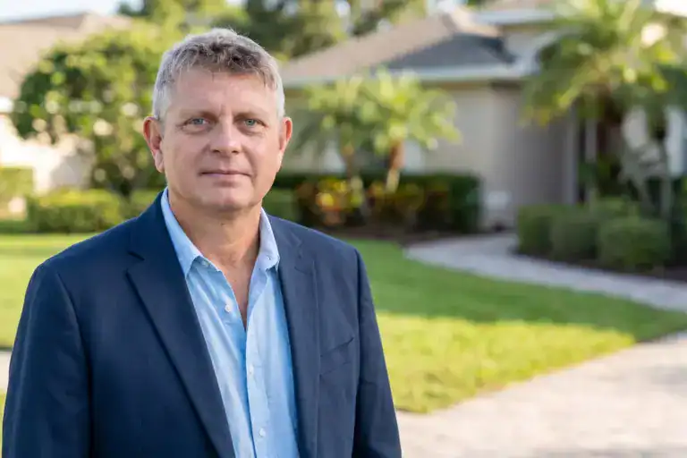 Axel Weiss, broker at Sea to Sky Realty, in front of a Florida home for sale